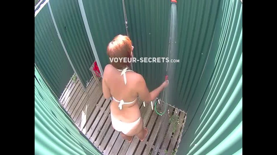 Mature lady caught in a beach shower
