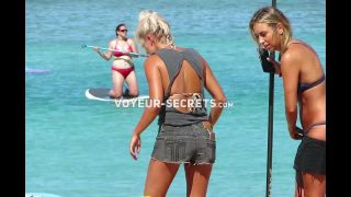 Hot beach girls paddle their surfboard
