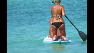 Hot beach girls paddle their surfboard