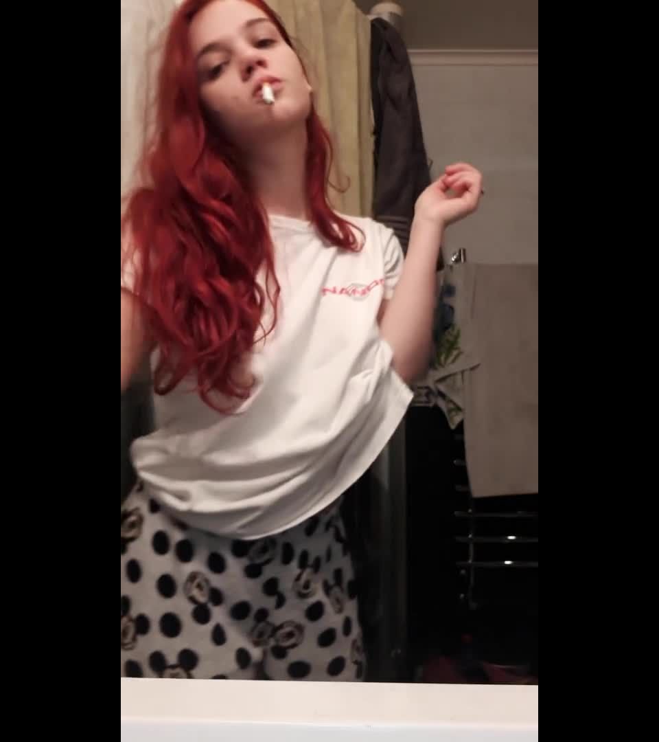 Curvy redhead smoking and undressing