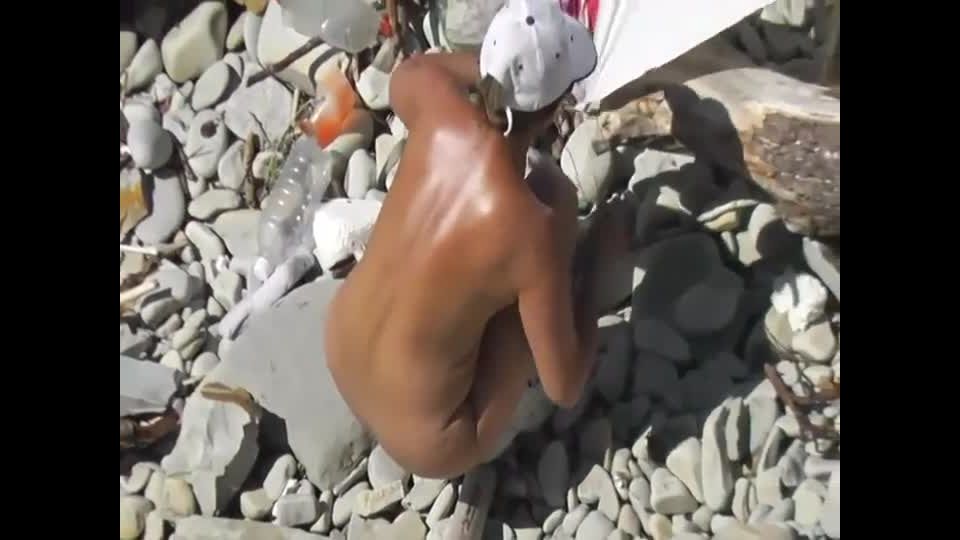 Mature nudist woman repairs the tent