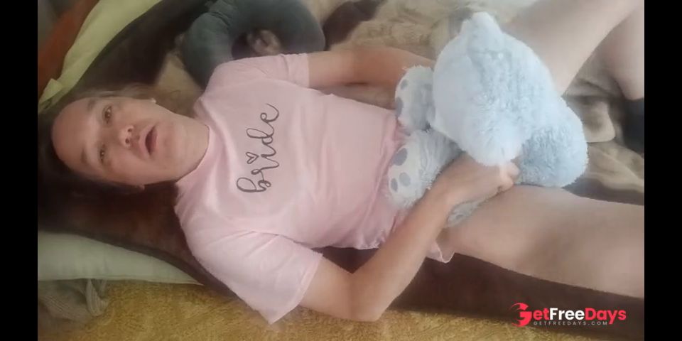 Lying with a teddy bear in a pink T-shirt