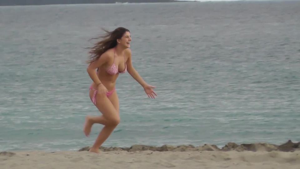 Cute girl chases friends on the beach