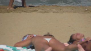 Alluring teens sunbathing on beach