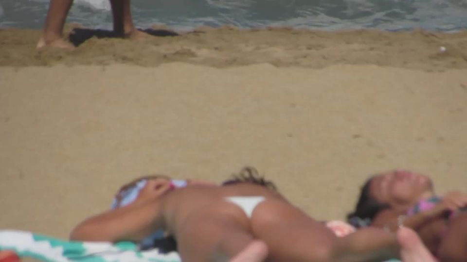 Alluring teens sunbathing on beach