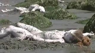 Bunch of nudists exercising on the  beach