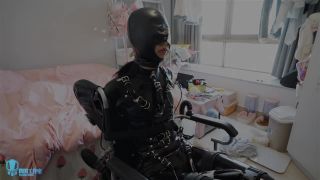 Miao in latex and gasmask on wheelchair